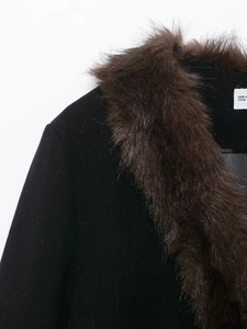 Detail of elegant black jacket featuring a warm brown faux fur collar and V-neckline