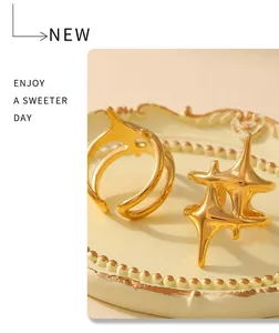 Artistic 18k gold plated stainless steel star and streamline rings on a vintage tray