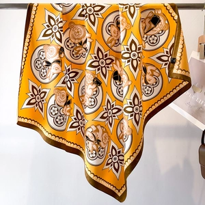 Detail of yellow silk scarf showing floral patterns and rabbit print draped on a rod
