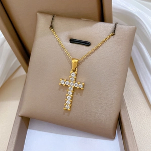 Close-up of a gold-plated titanium cross pendant inlaid with sparkling cubic zirconia