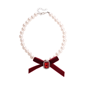 Elegant pearl necklace with a red velvet bow and shimmering rhinestone centerpiece