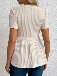 Beiges Umstands-Strickoberteil mit Schößchensaum, Rückansicht an einem Model gezeigt