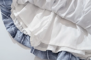 Detail of blue plaid skirt with layered structure and white inner lining fabric