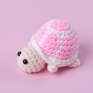 Handmade crochet mini turtle plush doll in pink and beige yarn for desk decoration
