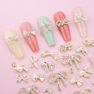 Bow-knot nail charms with crystals and pearls on elegant long artificial nails