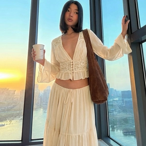 Close-up of beige lace chiffon top with deep V-neck and matching flowy long skirt