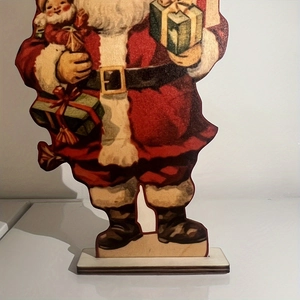 Close-up of vintage wooden Santa Claus desk ornament with gift box and wooden base