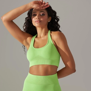 Detail of neon green seamless ribbed knit fabric on sports bra and leggings set