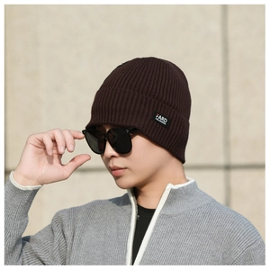 Detailed close-up of dark brown ribbed knit beanie featuring a high-quality FARD label
