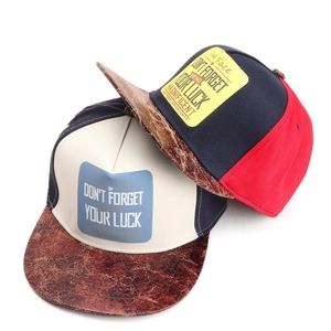 Close-up of snapback hats with color-block design and textured faux leather brims