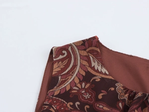 Détail de l'épaule d'une robe longue sans manches en mousseline avec imprimé paisley brun