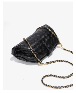 Detailed view of black woven leather shoulder bag with chic interwoven metal chain strap.