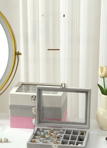 Close-up of stacking velvet jewelry boxes with transparent windows and metal buckles