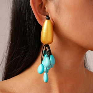 Ethnic style drop tassel earrings with gold texture and turquoise pendants on model