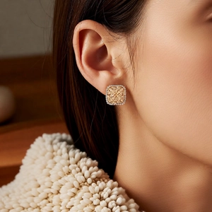 Close-up of champagne gold square zircon earrings on model for a luxury French look