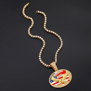 Détail du pendentif doré avec drapeau américain et aigle sur une chaîne de tennis