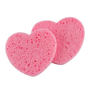 Two heart-shaped pink wood pulp sponges for facial cleansing and makeup removal