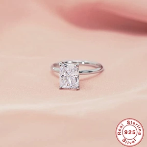 Macro view of a 925 sterling silver ring with a radiant rectangular-cut gemstone on silk
