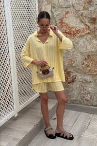Détail du tissu en maille ajourée jaune clair sur l'ensemble polo et short