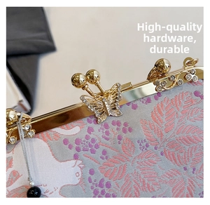Close-up of golden butterfly metal clasp with rhinestones on a brocade shell bag