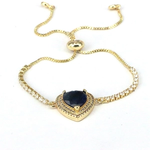 Close-up of heart-shaped dark blue gemstone bracelet with adjustable gold slider chain