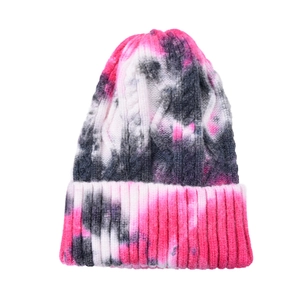 Detailed knit texture of tie-dye beanie featuring pink and black ribbed cuffs