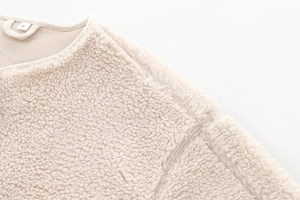 Detailed close-up of cream-colored teddy fleece texture and neckline on size S jacket