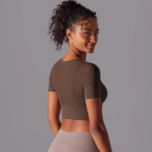 Detail of slim fit dark brown cropped yoga top with short sleeves and elastic breathable fabric