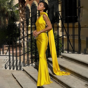 Detail of elegant yellow satin dress with long shoulder cape and sleeveless neck design