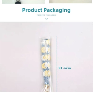 Detail of handmade crocheted daisy phone strap in packaging measuring 21.5cm long