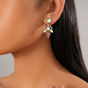 Élégant ensemble de six boucles d'oreilles dorées avec zircons de couleur sur modèle