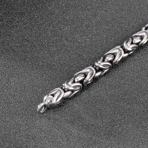 Close-up of vintage silver Byzantine chain link bracelet with industrial steel texture