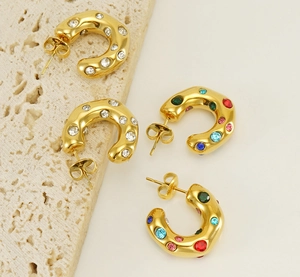 Macro view of four 18K gold-plated C-shaped earrings with colorful sparkling zircons