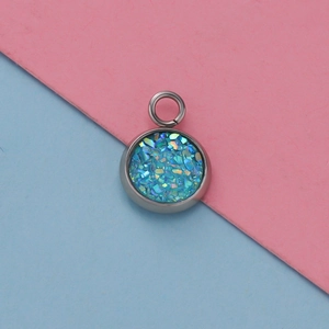 Close-up of 12mm blue glitter pendant charm with silver bezel for DIY jewelry making