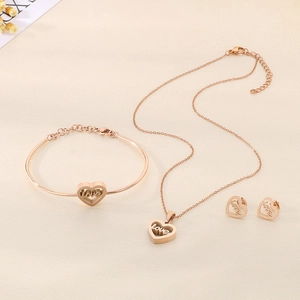 Detail of rose gold jewelry set featuring hollow heart pendants with LOVE engraving