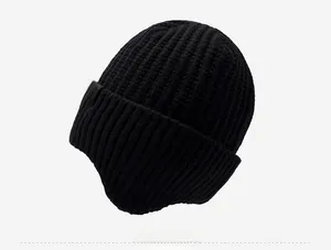 Détail du bonnet en maille noire avec texture côtelée et étiquette logo flocon de neige blanc