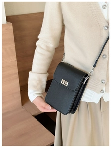 Close-up of black leather mini crossbody bag featuring a classic metal twist lock closure