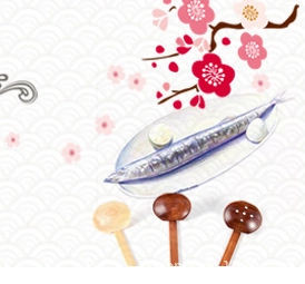 Japanese nanmu wood spoons displayed with cooked fish on a patterned floral background
