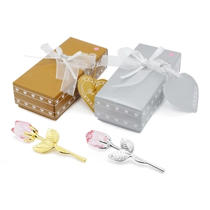 Vista dettagliata di rose di cristallo rosa con eleganti scatole regalo oro e argento