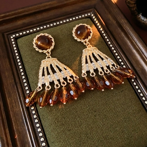 Vintage gold tassel earrings with tiger eye stone and crystal beads on green velvet