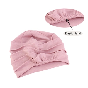 Detail of pink chemotherapy turban headwear showing elastic band and pleated texture