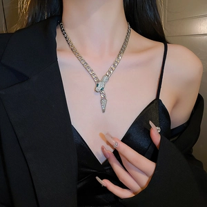 Close-up of silver snake pendant necklace with pavé-set crystals on thick link chain