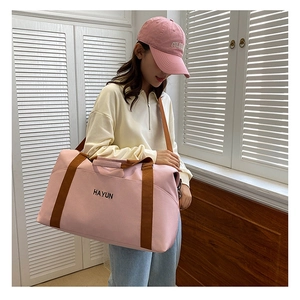 Pink large capacity yoga fitness travel bag with brown straps shown on shoulder