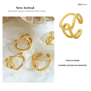 Detail of 18K gold plated double ring with cross design on white textured paper