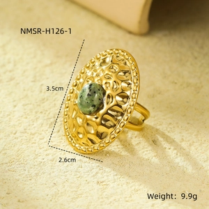 Detail of vintage oval green stone ring with hammered gold texture and beaded edges