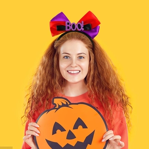 Detail of Halloween bow headband with purple glitter Boo! text and colorful ribbons