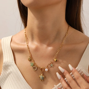 Gold necklace with ocean-themed pendants including blue sea turtle, starfish and shells
