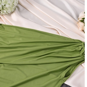 Detail of green knit fabric texture with elastic pleated design on white satin cloth
