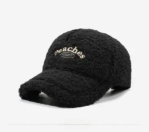 Detailed close-up of fluffy black sherpa texture and white peaches embroidery on baseball cap
