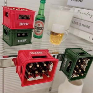 Miniature magnetic beer crate openers in red and green colors with realistic bottles